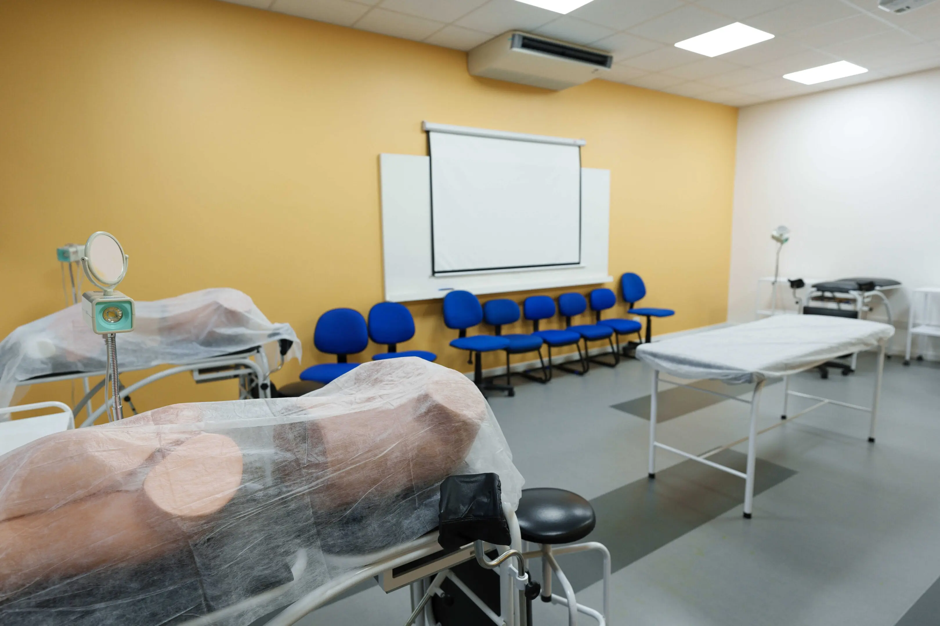 b Medical training room with equipment and chairs.